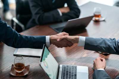 shaking hands during a meeting, symbolizing partnership or agreement